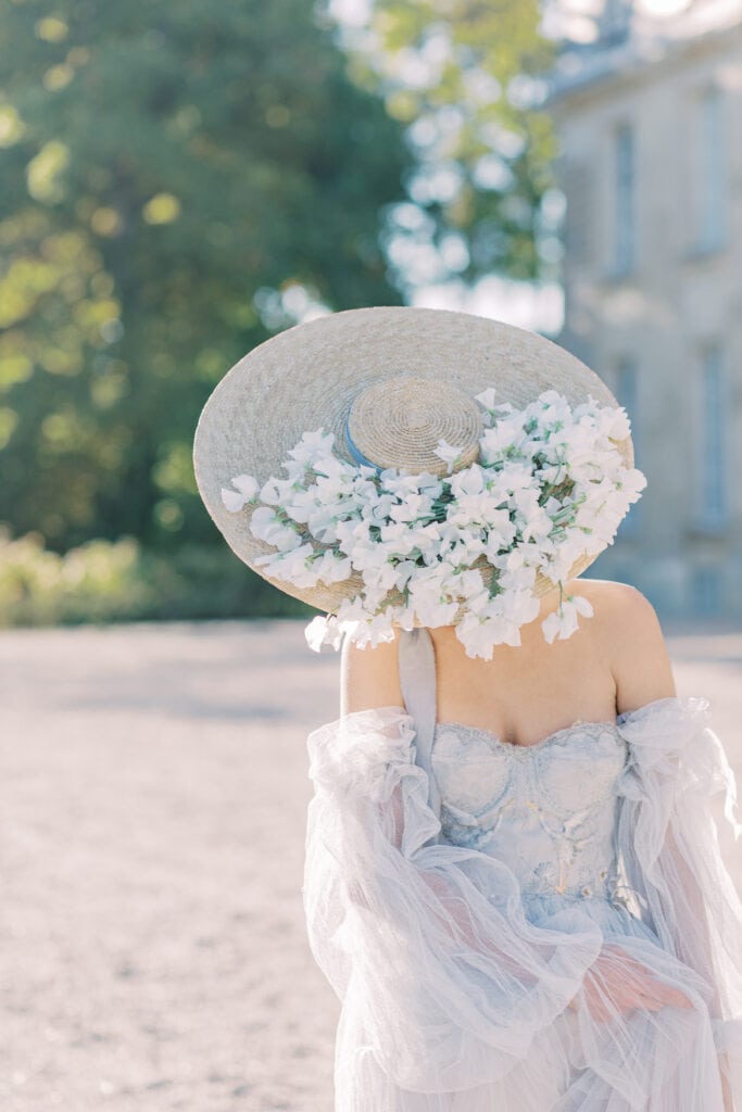 Braut mit einem Hut, der mit Blumen geschmückt ist