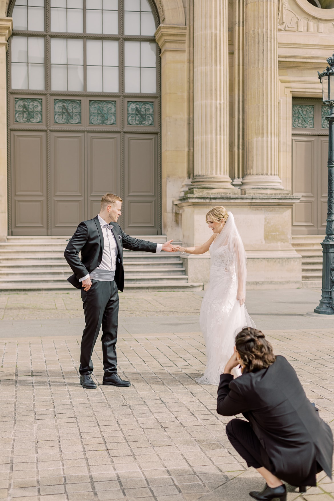 Fotografin hockt auf dem Boden und fotografiert von dort ein Hochzeitspaar