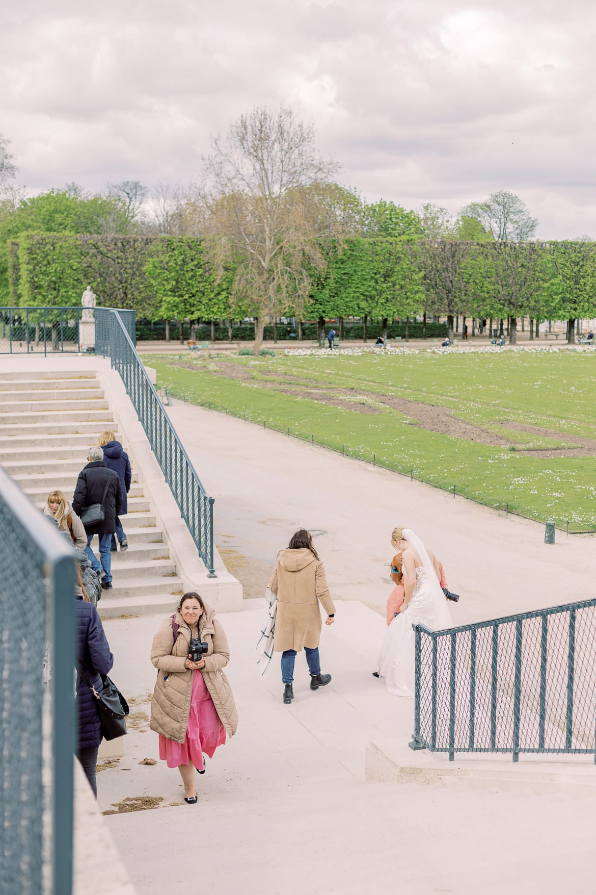 Fotografinnen und ein Hochzeitspaar auf einer Treppe in einem Park
