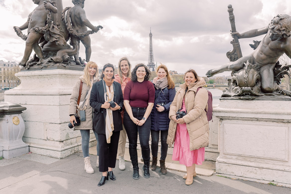 Ein Gruppenfoto mit 6 Frauen auf einer Brücke vor dem Eiffelturm